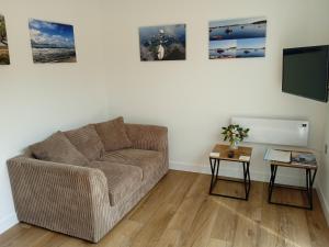 a living room with a couch and a tv at The Old Garage in West Itchenor
