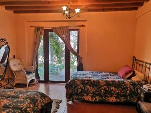a bedroom with two beds and a sliding glass door at Hermosa cabaña en Amealco centro in Amealco