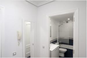 a white bathroom with a toilet and a sink at Luminoso y Azul VUT 4654 AS in Avilés +2 photos