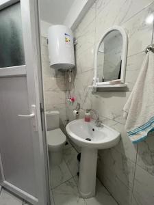 a bathroom with a sink and a toilet and a mirror at Kumburgaz Sahilde, Sitede, Konforlu, Manzaralı Klimalı Daire in Buyukcekmece