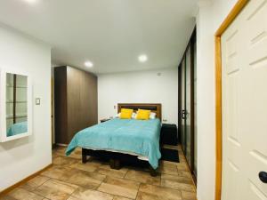 - une chambre avec un lit doté de draps bleus et d'oreillers jaunes dans l'établissement HOSPEDAJE SUSTENTABLE, à Calle Larga
