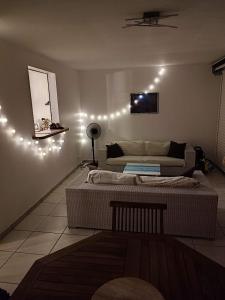 salon z 2 łóżkami i oświetleniem na ścianie w obiekcie Chez Mamie - La pagerie w mieście Les Trois-Îlets