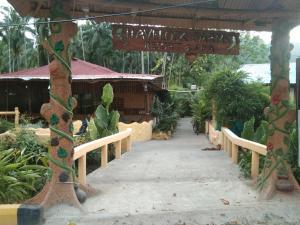 una pasarela en un jardín con plantas y un cartel en Havelock Farms Resort en Havelock Island