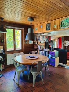 a dining room with a wooden table and chairs at Chambre d'hôtes Chalet AILLEURS in Molines-en-Queyras