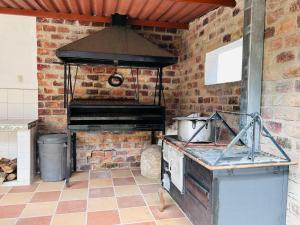 a kitchen with an oven and a brick wall at EL HATO HOME REST in Cachipay