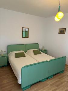 a bedroom with a blue bed with two pillows at Longa Rooms in Šibenik