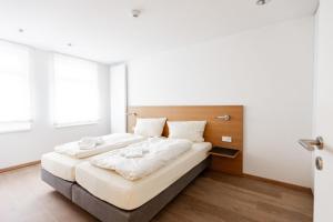 ein Schlafzimmer mit einem großen Bett mit weißer Bettwäsche in der Unterkunft Hotel Stadt Kassel in Rinteln