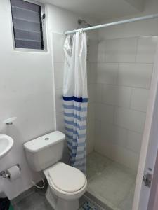 a white bathroom with a toilet and a shower at Apartamento Ricaurte in Ricaurte +15 photos