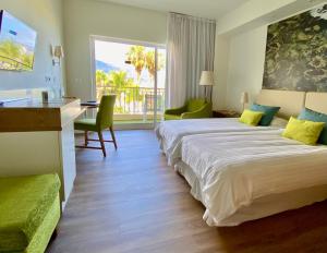 ein Hotelzimmer mit zwei Betten und einem Schreibtisch in der Unterkunft Hotel Tigaiga in Puerto de la Cruz + 36 Fotos