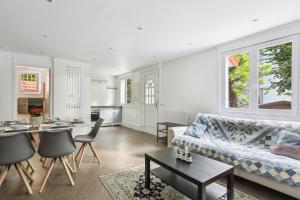 ein Wohnzimmer mit einem Sofa und einem Tisch in der Unterkunft Maison charmante avec jardin et parking offert Paris St Cloud in Saint-Cloud