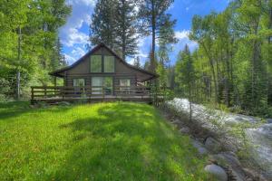 a cabin in the woods with a green lawn at 235 Verde Lane Hideaway River Cabin in Vallecito
