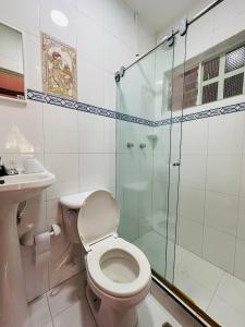 a bathroom with a toilet and a glass shower at EL HATO HOME REST in Cachipay