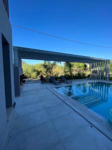 a house with a swimming pool and a patio at Grand Kourouta in Kourouta