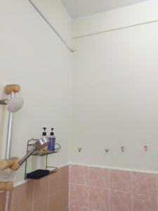een badkamer met een douche met roze tegels aan de muur bij Welcome to Gemas Homestay ALI 