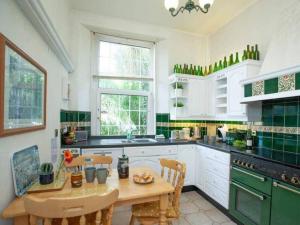 a kitchen with a wooden table and green appliances at Detached period house in sought after location in Torquay