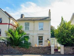 a white house with a fence in front of it at Detached period house in sought after location in Torquay