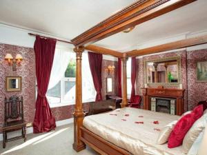 a bedroom with a canopy bed and a fireplace at Detached period house in sought after location in Torquay