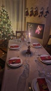 a table with wine glasses and a christmas tree at Las Golondrinas de Henche 