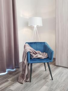 圣安吉洛Flat 252 Sorrento Apartments的一张毯子放在蓝色椅子上，还有一盏灯