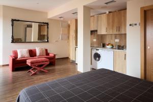 a living room with a red couch and a kitchen at Lagares de Riooja-Briñas in Briñas