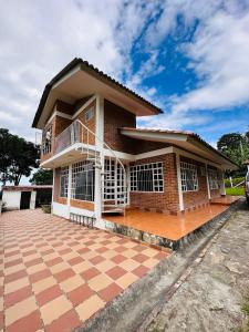 a house with a large patio in front of it at EL HATO HOME REST in Cachipay
