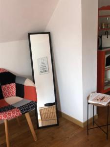 un miroir et une chaise dans la chambre dans l'établissement Belle Chambre Double ORANGE Tout Bonnement Bien, à Putot-en-Auge