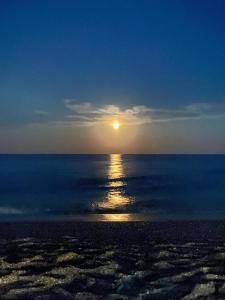 un tramonto sull'oceano con il sole nel cielo di Bella Terra Hotel a Asprovalta