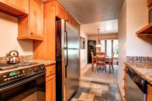 a kitchen with a stainless steel refrigerator and a dining room at Beautiful Townhome Short Walk to Slopes and Town - LW01 in Breckenridge