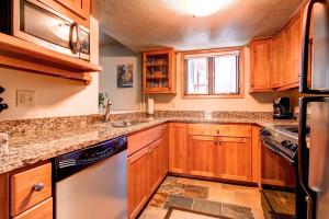 a kitchen with wooden cabinets and a window at Beautiful Townhome Short Walk to Slopes and Town - LW01 in Breckenridge