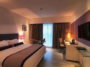 浦那Spree Shivai Hotel Pune的配有床和书桌的酒店房间