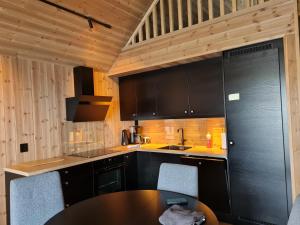 Bud的住宿－Rorbu ved sjøen，厨房配有黑色橱柜和桌子
