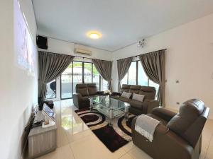 uma sala de estar com sofás e uma mesa de vidro em Solitude Staycation By HomestayJB em Kangkar Pendas