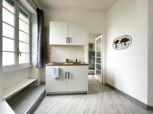 uma cozinha com armários brancos e uma janela em Vatican Home Holidays em Roma