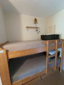 a wooden bunk bed in a room with a shelf at Appt 4 pers au Pla d' Adet, Résidence le Grand Stemm , station de ski Saint Lary in Saint-Lary-Soulan
