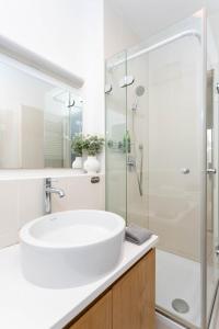 uma casa de banho branca com um lavatório e um chuveiro em Paulay65 Budapest em Budapeste