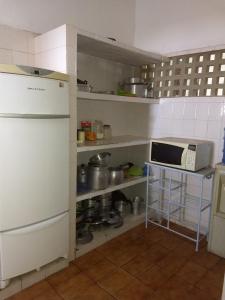 W kuchni znajduje się biała lodówka i kuchenka mikrofalowa. w obiekcie Praia dos Carneiros w mieście Tamandaré