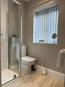 a bathroom with a shower and a toilet and a window at New Stylish Sleeps 7 free parking contractors welcome in Birmingham
