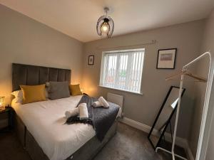 1 dormitorio con cama y ventana en New Stylish Sleeps 7 free parking contractors welcome en Birmingham