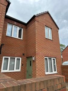 a red brick house with a green door at New Stylish Sleeps 7 free parking contractors welcome in Birmingham
