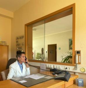 Ein Mann, der am Schreibtisch sitzt und telefoniert in der Unterkunft Kloster Esthal in Esthal