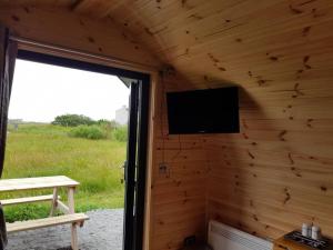 a room with a wall with a television on it at Hoilisgeir Self Catering Pod in Daliburgh