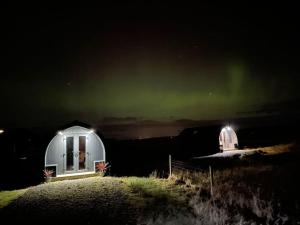 a couple of observatories with the aurora in the sky at Hoilisgeir Self Catering Pod in Daliburgh