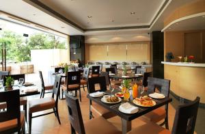 浦那Spree Shivai Hotel Pune的有桌椅的餐厅，上面摆着食物
