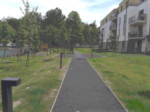 a walking path in a park next to a building at Confortable T2 NEUF - RDC - 2/4 personnes in Mondeville