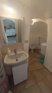 y baño con lavabo, aseo y espejo. en Trullo Alberobello Vacanze Desà 2 en Alberobello