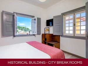 Casa Senhoras Rainhas AL - Obidos - by Unlock Hotels في أوبيدوس: غرفة نوم بسرير ونافذة