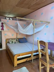 1 dormitorio con 1 cama con hamaca y silla en Jardin Nature, en Bopa