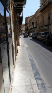 an empty street with cars parked on the side of a building at Benvenuti al Sud B&B in Licata