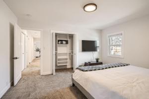 a white bedroom with a bed and a television at 6224 S Datura St in Littleton