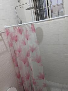 a shower curtain with pink flowers on it in a bathroom at Mninga Classic Lodge, Ilazo in Dodoma